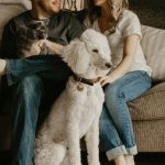 A young couple with a poodle dog in their first home